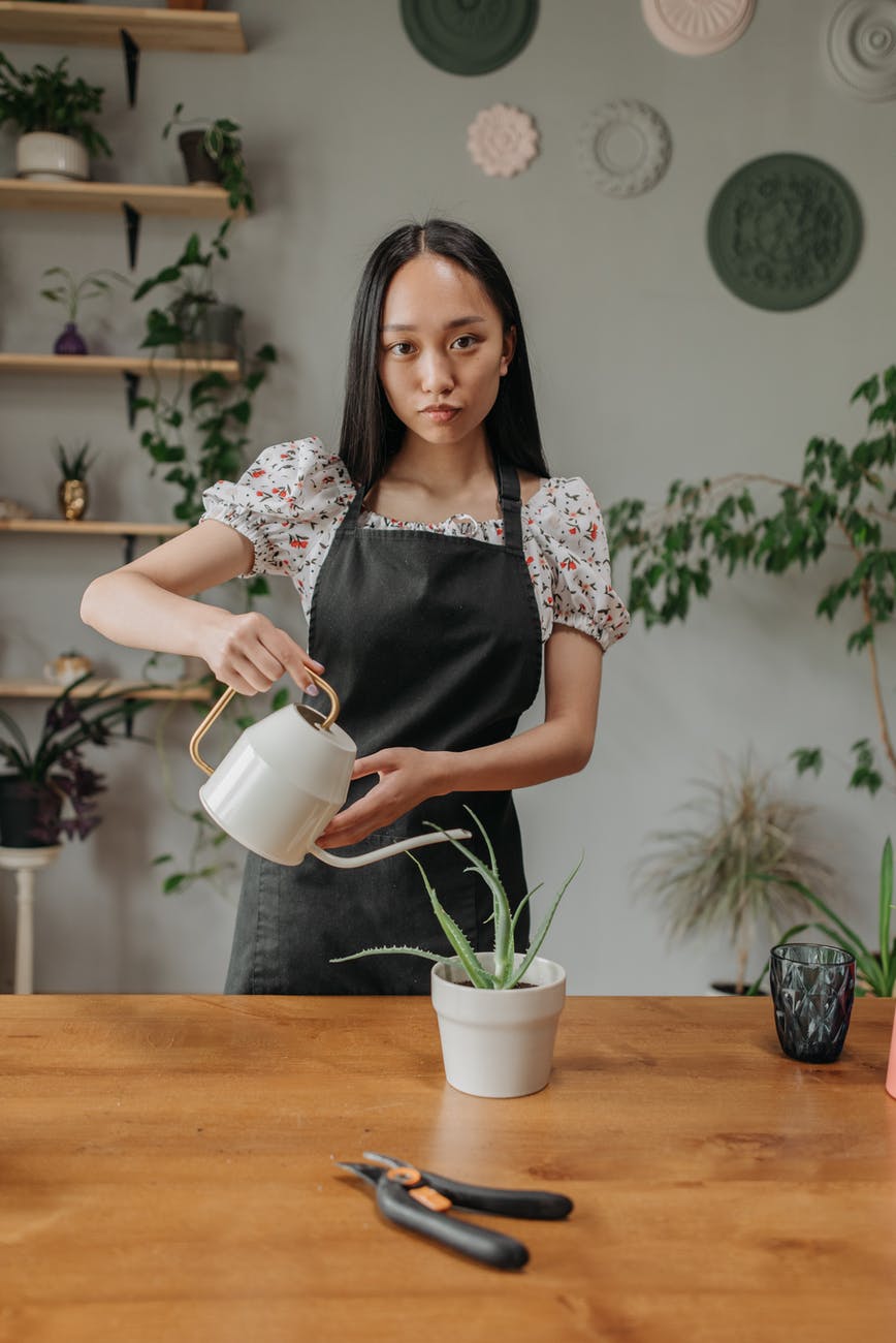 a woman holding a watering pot