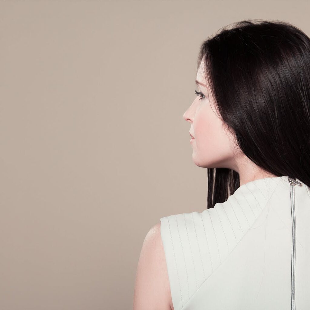 woman in white sleeveless high neck top showing her back