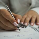 Say Goodbye to Weak Nails with Aloe Vera Power! Woman in White Long Sleeved Shirt Holding a Pen Writing on a Paper