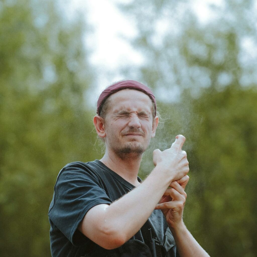 Man Spraying His Face Outdoors