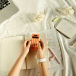 Person Holding Orange and White Iphone Case