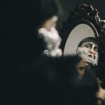 Say Goodbye to Greasy Locks with Aloe Vera Hair Treatments A woman with a face mask is looking in a mirror