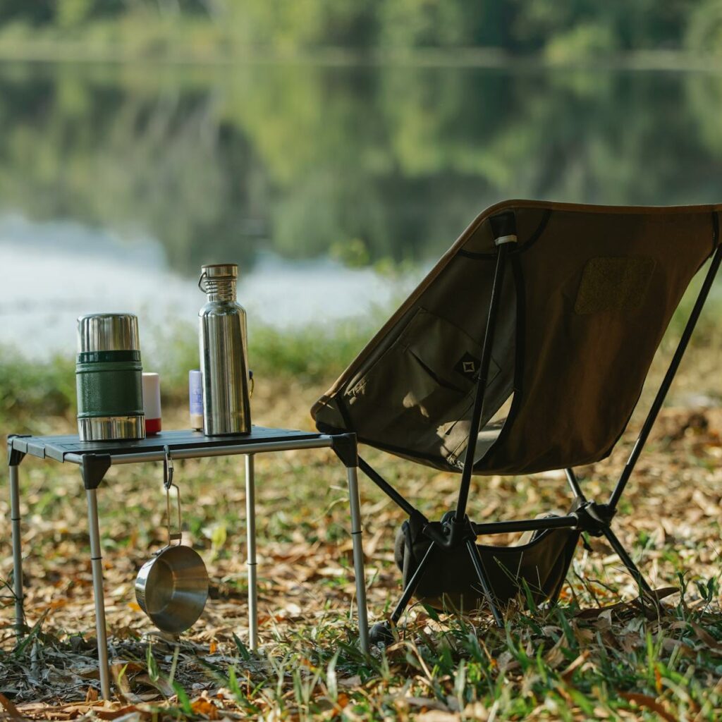 Camping chair near table on river shore