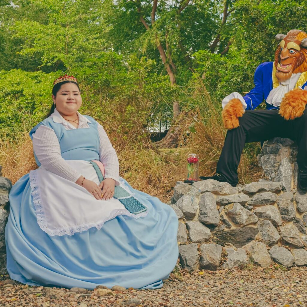 A woman in a blue dress and a man dressed as beast