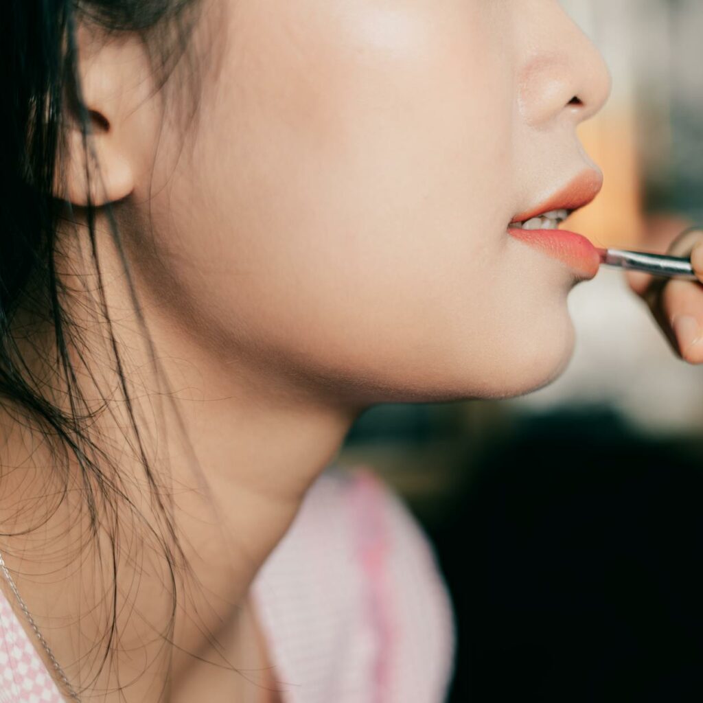 Close-up of Painting Woman Lips with Lipstick